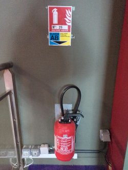Fire extinguisher in a public-access building, under its fire-class signage